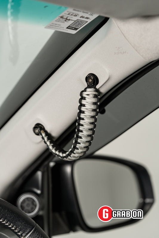 Car door handle with a coiled rope attached, brand 'Grabon' visible.